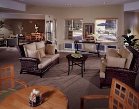 A living room with a brown sofa, a brown table, and a brown chair.