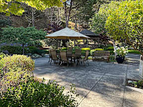 A patio with a table and chairs under an umbrella.