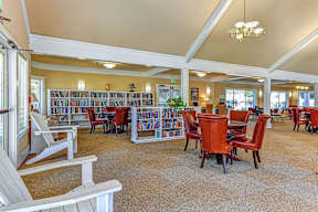 A library with red chairs and bookshelves.