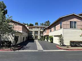 A sunny day at a residential complex with a clear blue sky.