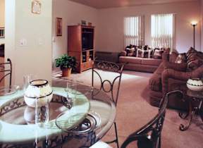 A living room with a glass table and chairs.