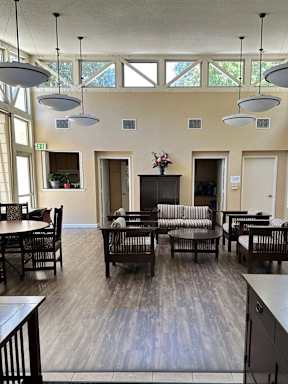 A large room with tables and chairs and a fireplace.