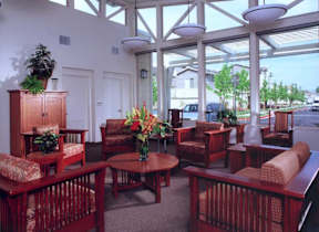 A room with wooden furniture and a large window.
