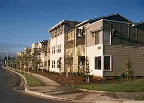 A street view of a residential area with houses on the right.