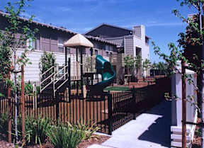 A playground with a slide and a wooden fence.