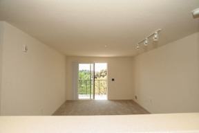 A room with a sliding glass door leading to a balcony.