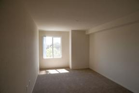A room with a window and carpeted floor.