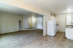 A kitchen area with a refrigerator, sink, and cabinets.at Terra Linda Manor, San Rafael