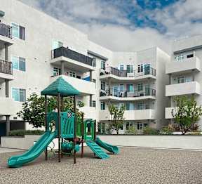 A playground with a green slide and a green canopy.