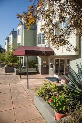 A building with a red awning and a bench in front of it.