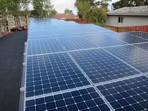 A large array of solar panels are installed on a roof.
