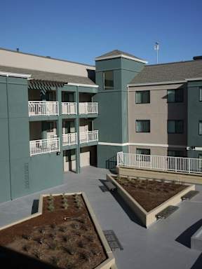 Apartment complex with greenery in the courtyard.