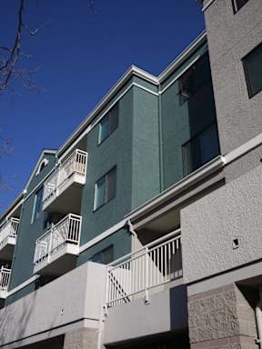 A building with balconies and a clear blue sky.
