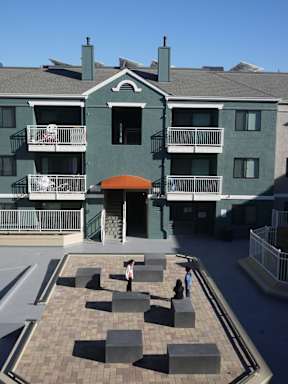 A courtyard with a few people sitting on the benches.