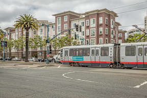 A train is on the tracks in front of a building.