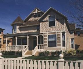 A house with a white picket fence in front.