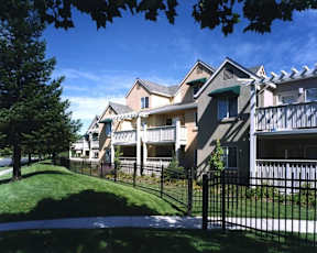 A row of houses with a black fence in front.