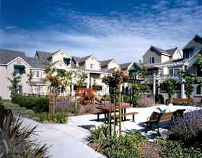 A sunny day at a residential area with houses and a picnic table.