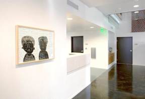 A picture of two people is hanging on a wall in a hallway.