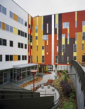 A modern building with a courtyard and a fence.