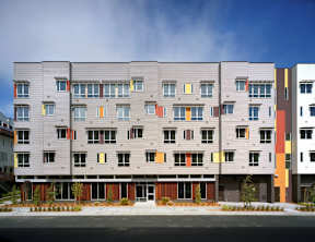A modern apartment building with grey and orange accents.