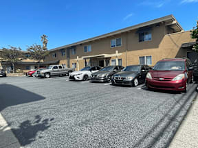 A parking lot with cars parked in front of a building.