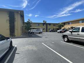A parking lot with cars and a building in the background.