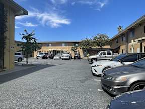 A parking lot with cars parked in front of a building.