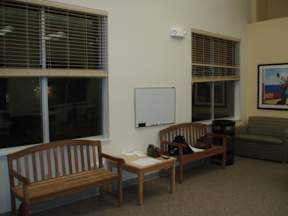 A room with a whiteboard and two wooden benches.