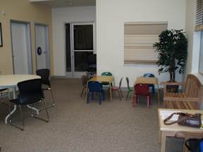 A room with a table, chairs, and a plant.