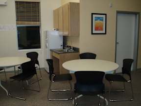 A kitchen area with a table and chairs.