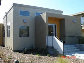 A house with a yellow door and a small porch.