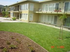 Apartment complex with a green lawn in front.