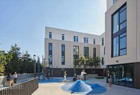 A modern building with a playground in front.