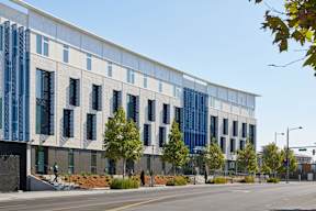 A modern building with a blue glass facade and white trim.