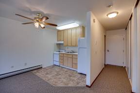A kitchen with a fan and a refrigerator.