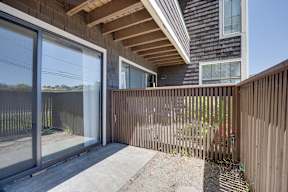 A modern house with a wooden fence and glass doors.