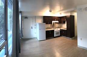 A kitchen with white appliances and dark brown cabinets.