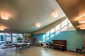 A room with a piano and a table with chairs.