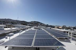 A large array of solar panels are installed on a roof.