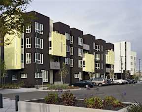 Apartment complex with cars parked in front.