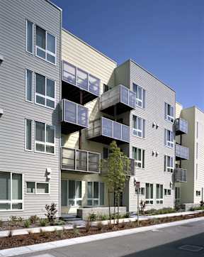 A modern apartment building with balconies and a clear blue sky.