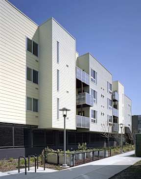A modern apartment building with a white exterior and balconies.