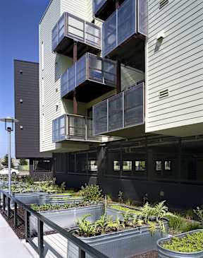 A modern building with a balcony garden in front.