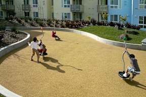 Children playing on a playground with a yellow surface.