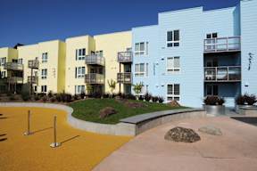 A playground area in front of apartment buildings.