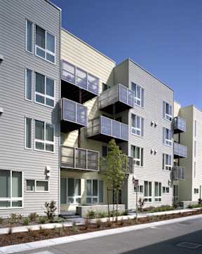A modern apartment building with balconies and a clear blue sky.