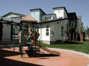 A child playing on a slide in a playground.