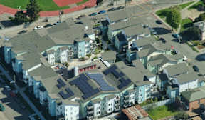 A view of a residential area with houses and a running track.