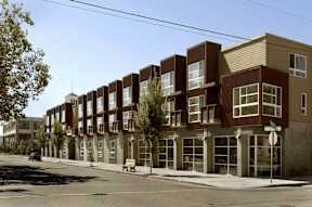 A street view of a row of modern apartment buildings.